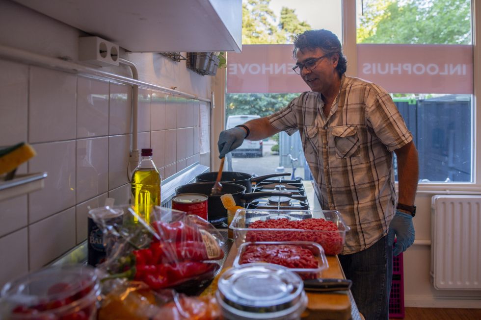 Bewoner die in het wijkinloophuis aan het koken is