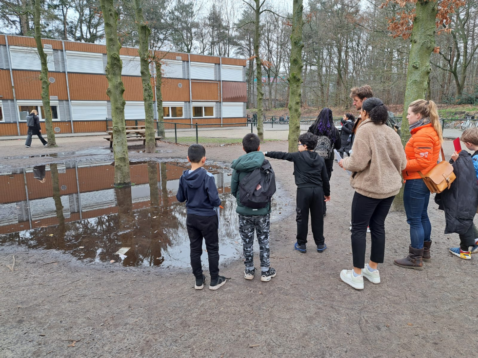 Kinderen staan bij de Wegwijzer en geven hun mening erover aan volwassenen