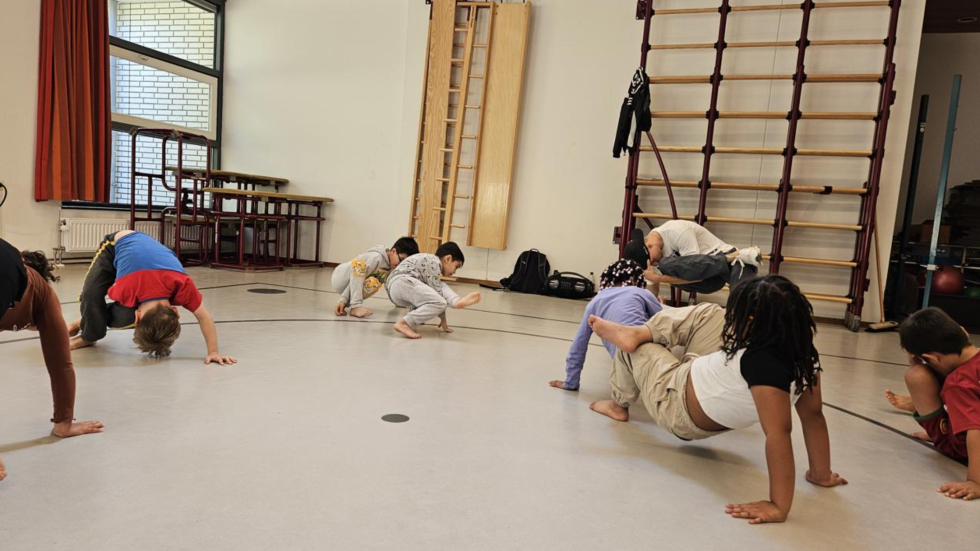 Kinderen doen een dansworkshop in de gymzaal