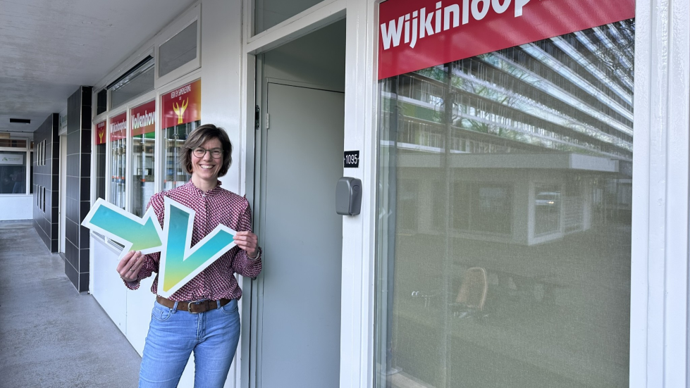 Elsbeth staat voor het Wijkinloophuis en houdt de pijl van Vollenhove Vooruit in haar handen